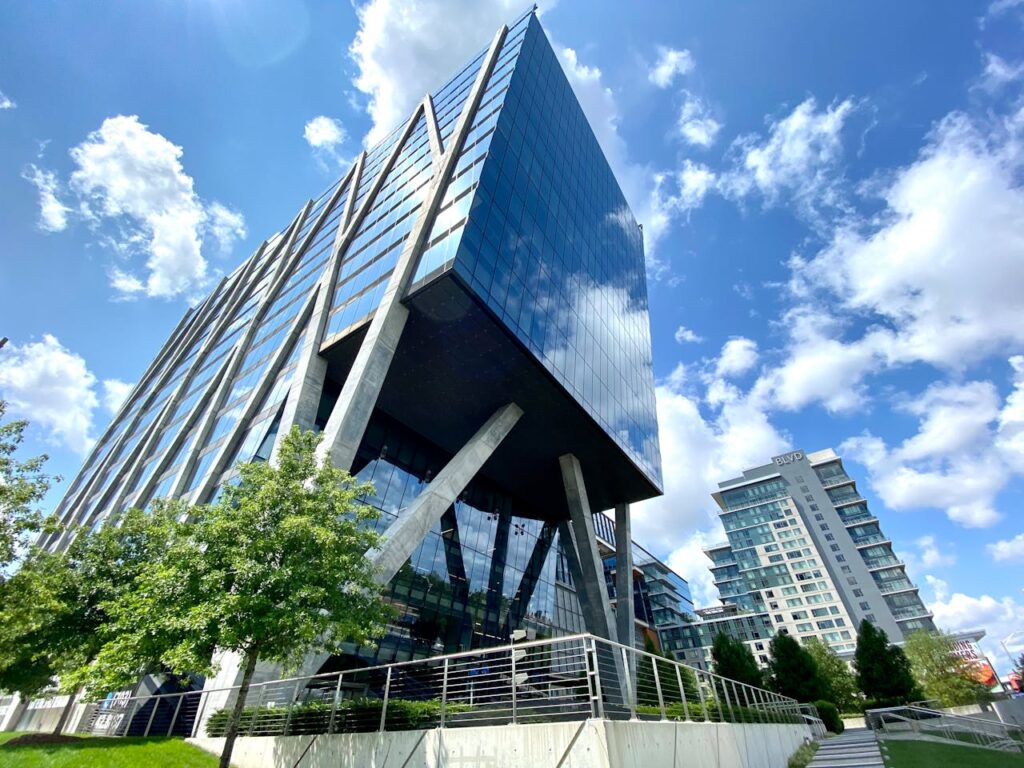 A striking modern office building with glass facade in Reston, VA under a clear blue sky.